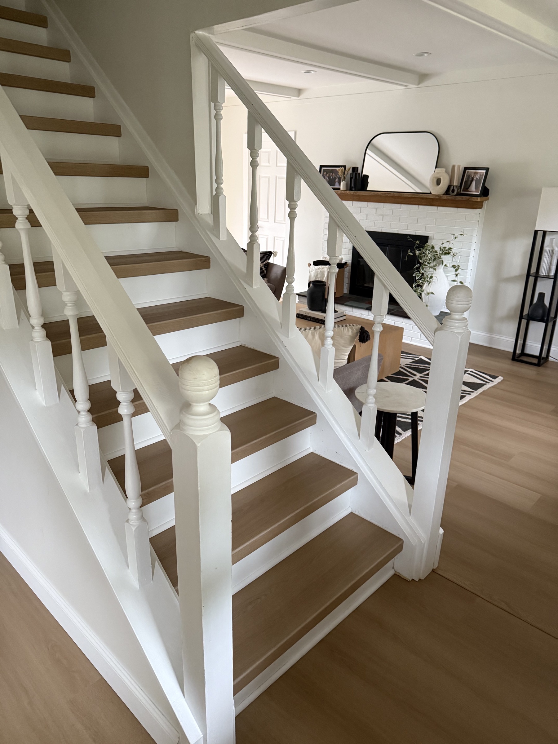 Natural oak vinyl stair treads with white risers on a wraparound staircase
